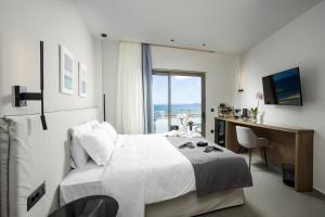 a bedroom with a bed and a desk and a window at Iria Sea View Room in Kolymvari