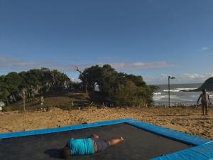 a man laying on a trampoline on the beach at Emaplangeni Lodge in Mtumbane +3 photos