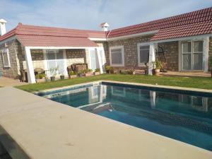 a swimming pool in front of a house at VILLA Tej el moulk in Es Somaa