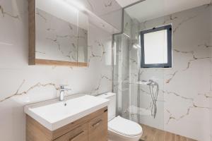 a bathroom with a sink and a toilet and a shower at K Houses I4 in Lefkada +5 photos