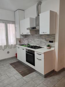 a kitchen with white cabinets and a stove top oven at Marconi in Novi Ligure
