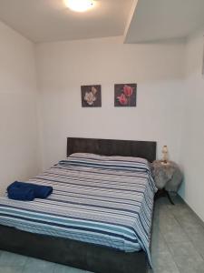 a bed in a bedroom with two pictures on the wall at Marconi in Novi Ligure