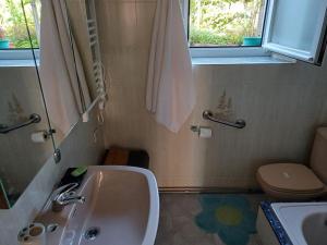 a bathroom with a sink and a toilet and a window at Casa descanso en familia junto a la playa y rio in Rianjo +21 photos