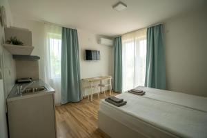 a bedroom with a bed and a kitchen with a sink at Milutinn-Trešnja in Soko Banja