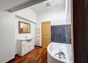 un baño con bañera y lavabo en Le relais des forges, en Saint-Leu-dʼEsserent
