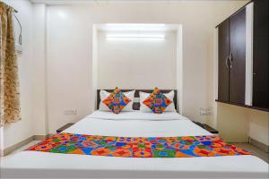 a bedroom with a bed with a colorful blanket on it at FabHotel Destination 42 - Nr Pheonix Mall in Kharadi +22 photos