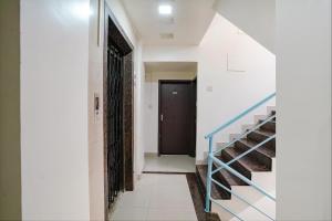 a hallway with a staircase and a black door at FabHotel Destination 42 - Nr Pheonix Mall in Kharadi
