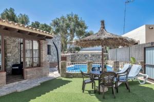 a patio with a table and chairs and an umbrella at Casas al Alba in Zahora