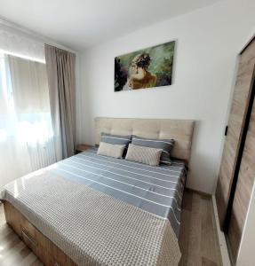 Un dormitorio con una cama con un cuadro en la pared. en Christal Apartment, en Bacău