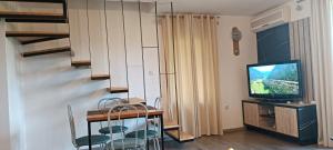 a living room with a television and a table and chairs at Pyramid Holiday House in Visoko