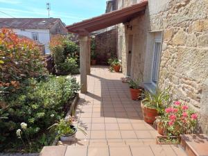 a patio with potted plants and a brick building at Casa descanso en familia junto a la playa y rio in Rianjo