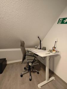 an office with a desk with a chair and a computer at Ferienwohnung Freedom 1 Sky Terrasse High End in Northeim +8 photos