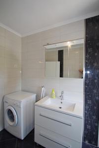 a bathroom with a washing machine and a sink at Apartments Nikolina in Rakalj +67 photos