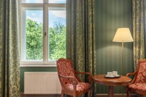 a room with two chairs and a table and a window at The Benjamin House in Rīga