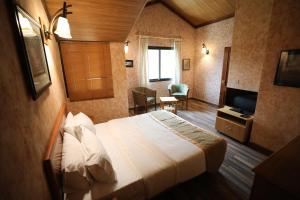 ein Hotelzimmer mit Bett und Fernseher in der Unterkunft Pineland Hotel and Health Resort in Ḩammānā