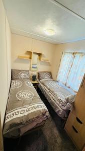 a small room with two beds and a window at Harts Holiday Park Kent London in Leysdown-on-Sea