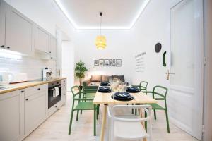 a kitchen with a table and green chairs in it at Very Central - Sunny - Comfy in Budapest +28 photos