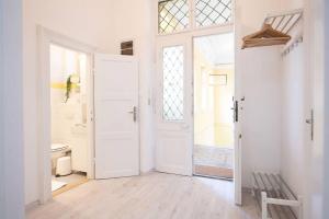 a white hallway with a door and a window at Very Central - Sunny - Comfy in Budapest