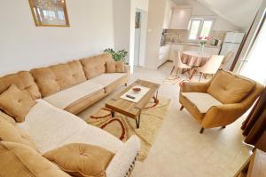 a living room with a couch and chairs and a table at Sun Apartment in Tivat