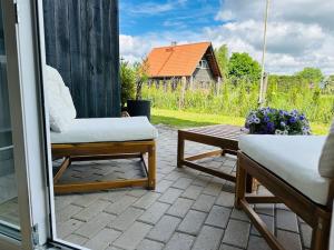 a porch with a chair and a bench and a table at Cozy apartment with terrace! in Sigulda