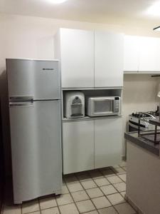 ナタールにあるCosteira Praia Flat 119の冷蔵庫と電子レンジ付きのキッチン