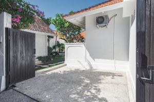a white garage with a door and a house at Green Garden Seminyak Villa in Seminyak