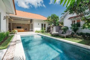a swimming pool in the backyard of a home with a house at Green Garden Seminyak Villa in Seminyak