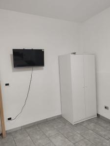 two white wardrobes with a television on a wall at Marconi in Novi Ligure +3 photos