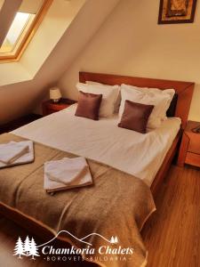 a bedroom with a large bed with white sheets and pillows at Chamkoria Chalets 409 in Borovets