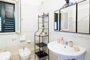 Un baño con lavabo, inodoro y espejo. en Casa Querencia rooms, en Palermo 23 fotos más