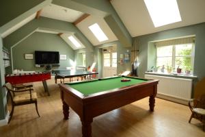 a living room with a pool table and a tv at Bookers Cottage in Bruern