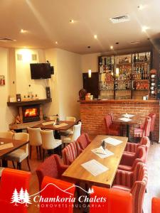 a restaurant with tables and chairs and a fireplace at Chamkoria Chalets 409 in Borovets