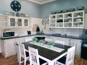 a kitchen with a table and chairs and a clock at Picanha Guesthouse in Heidelberg
