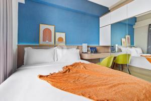 a hotel room with a large bed and a desk at Caleido by Kozystay - BSD in Tangerang +20 photos