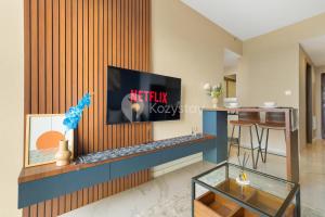a living room with a tv on a wall at Caleido by Kozystay - BSD in Tangerang