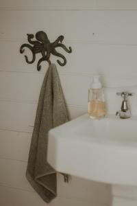a towel hanging on a wall next to a sink at Quaint and intimate 1-bed seaside cottage in Bridport
