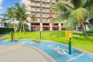 a playground in front of a building with palm trees at Caleido by Kozystay - BSD in Tangerang