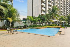 a swimming pool in front of a tall building at Caleido by Kozystay - BSD in Tangerang