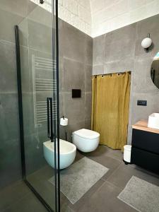 a bathroom with a toilet and a glass shower at Casa Rara al Mare in Monopoli