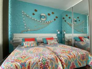 a bedroom with a large bed and a blue wall at Starfish Home, AWESOME VIEWS, FREE WIFI & NETFLIX in Morro del Jable