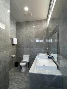 a bathroom with a sink and a toilet and a mirror at Prod Place - Sunny Chiang Rai in Chiang Rai