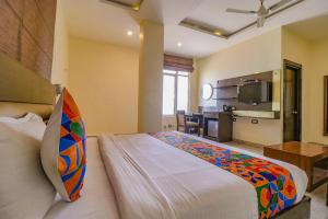 a hotel room with a large bed and a kitchen at FabHotel Narula in Dehradun