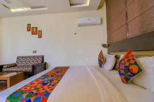 a bedroom with a large bed with colorful pillows at FabHotel Narula in Dehradun