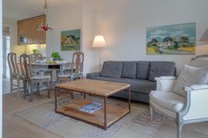 una sala de estar con un sofá y una mesa en Deichgraf 3, en Kampen