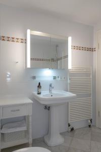 Un baño blanco con lavabo y espejo. en Deichgraf 3, en Kampen