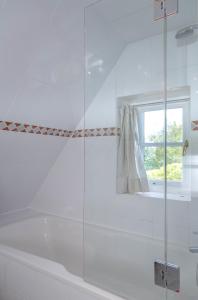 uma cabina de duche em vidro numa casa de banho com uma janela em NEU 2023 - Deichgraf 2 em Kampen