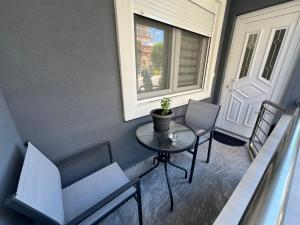 a balcony with a table and chairs and a window at Elegant Loft 2 in Alexandroupoli