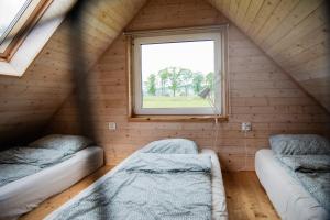 a room with two beds and a window at Alicjówka - domek in Marciszów