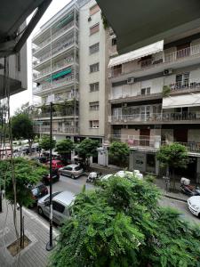 a parking lot with cars parked in front of a building at Urban Harmony Apartment in Thessaloniki