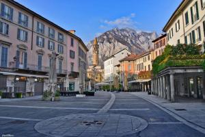 a city street with buildings and a mountain in the background at Huonder House in Lecco